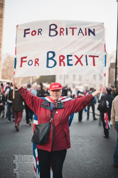 A woman holding a banner that says "For Britain, For Brexit"