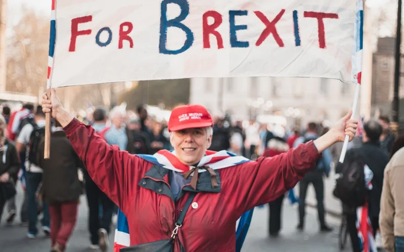 Uma mulher segura uma faixa que diz "Pela Grã-Bretanha, pelo Brexit"