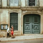 Foto de dos personas caminando por una calle de Lisboa, Portugal.